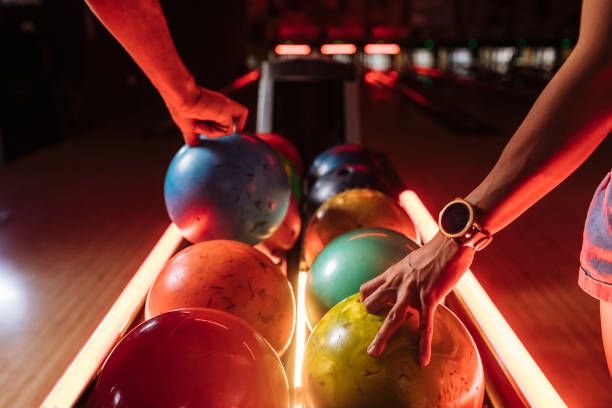 bowling players picking up balls from the rack